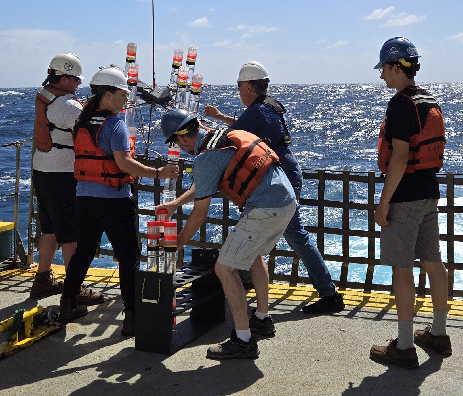 Researchers deploying sampling equipment at sea