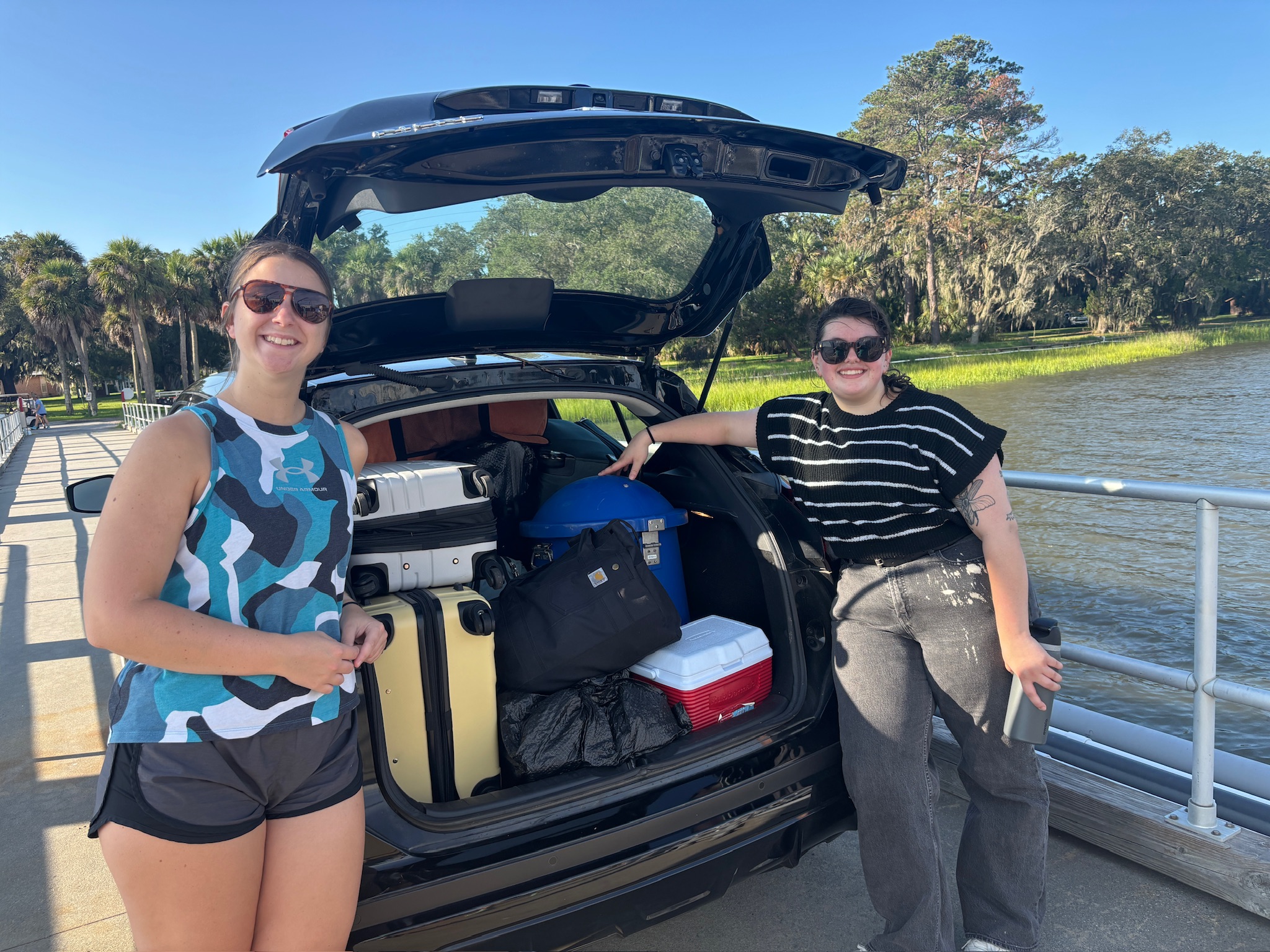 Jordan and Julia beside a car packed with lab equipment